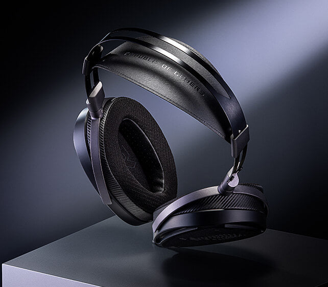 Top view of the ROG Kithara headset is displayed on a pedestal, illuminated by a spotlight against a dark background, showing the extended padded headband