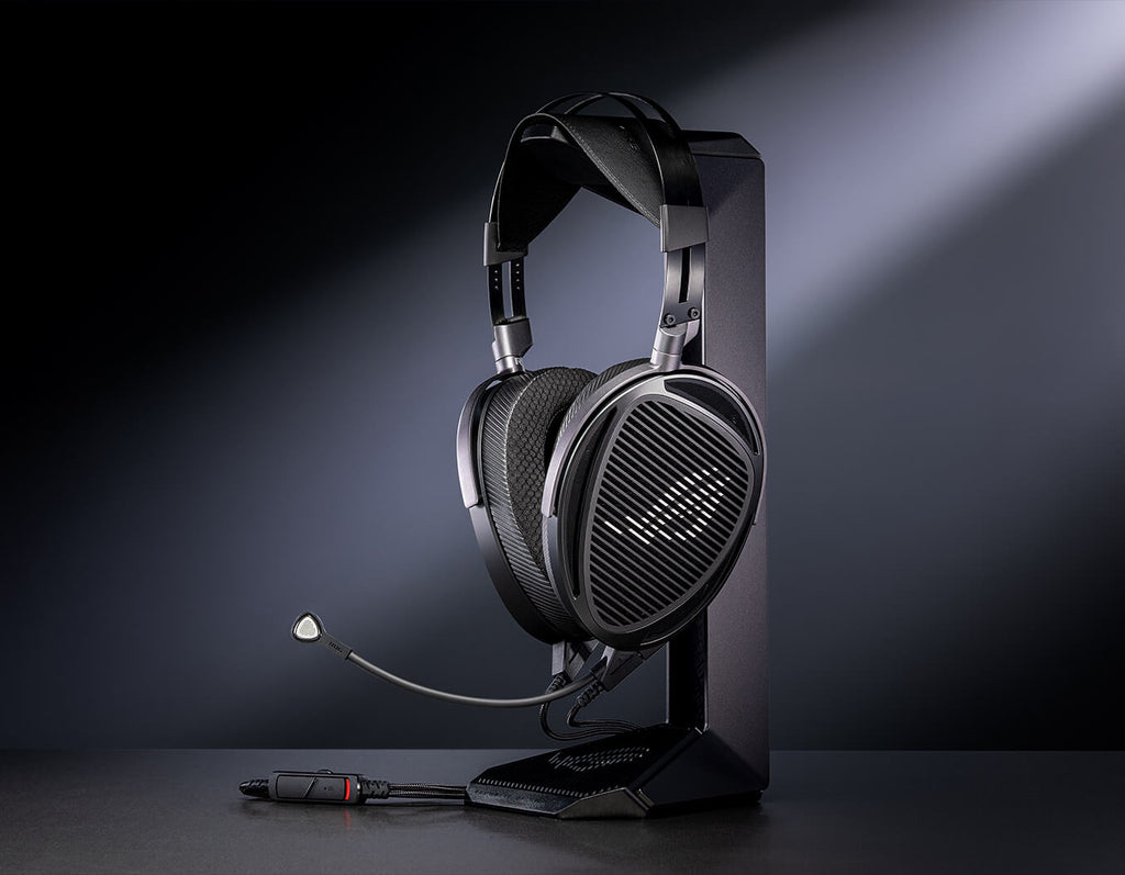 The ROG Kithara is displayed on a stand, with a boom microphone cable and in-line control placed beside it under focused lighting.