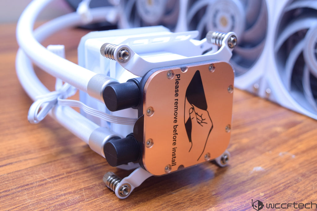 A close-up of a CPU cooler pump with an attached label reading 