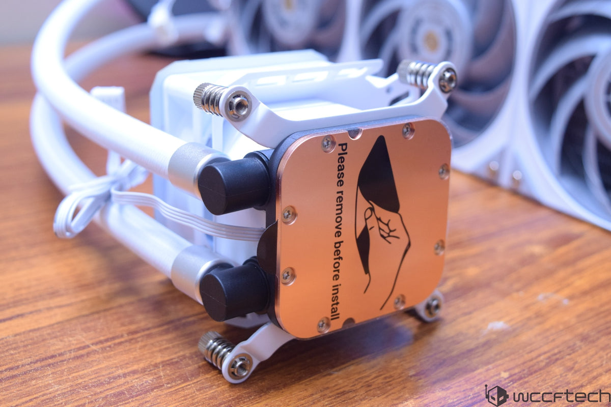 A close-up of a CPU cooler pump with an attached label reading 