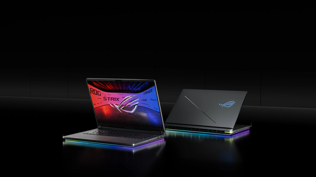 Two ROG Strix laptops on a table with the lids partially opened.
