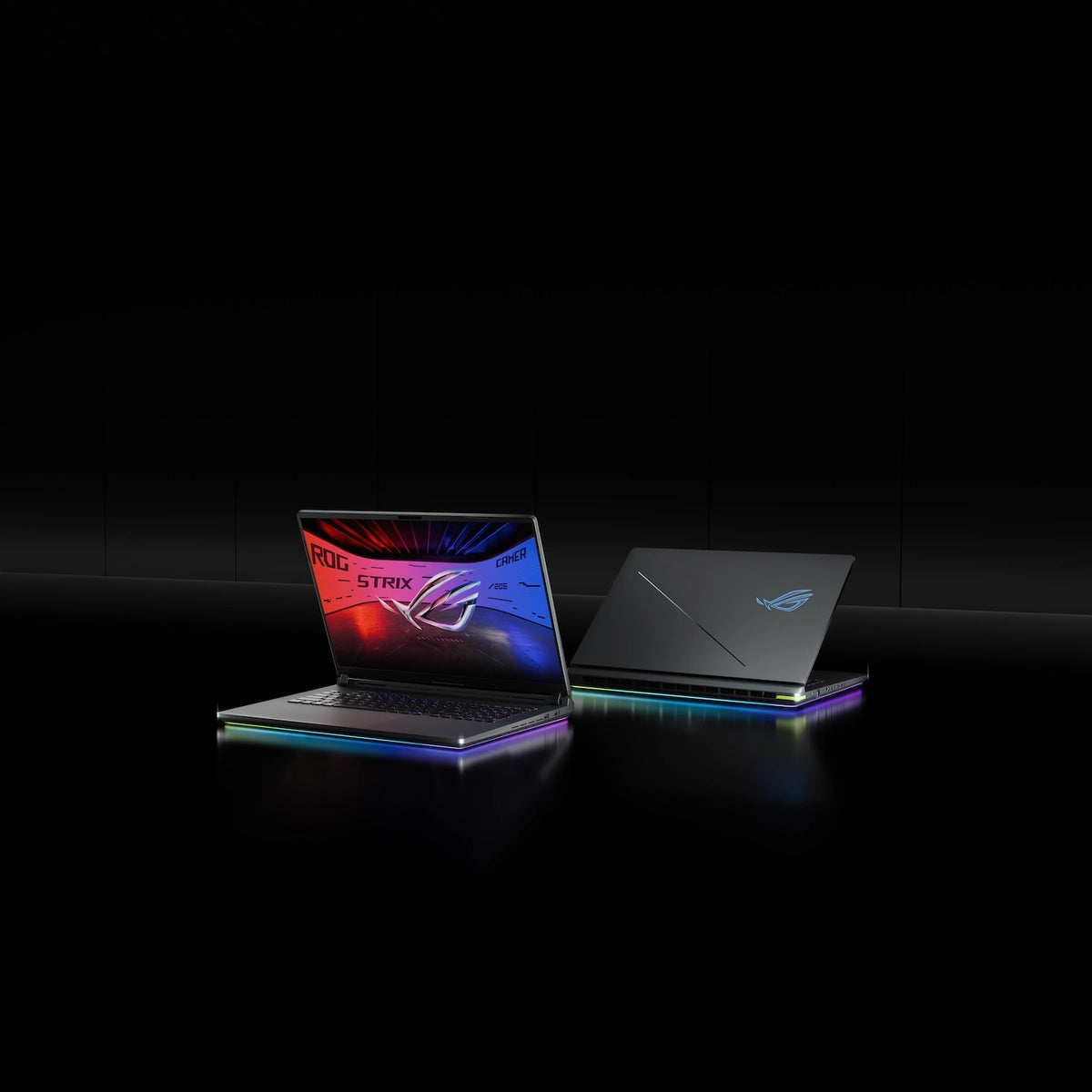 Two ROG Strix laptops on a table with the lids partially opened.