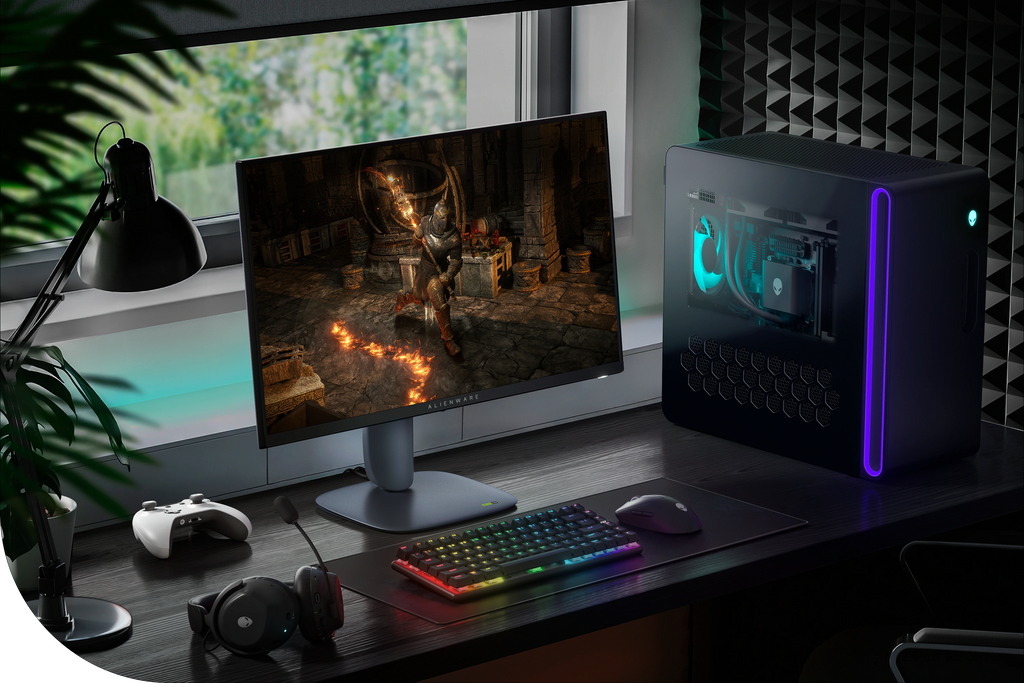 The Alienware 27 Gaming Monitor at a gaming desk setup with a desktop, headphones, game controller, keyboard and mouse
