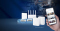 The ExpertWiFi product lineup in a café setting, with a hand holding a phone showing the ExpertWiFi SDN feature UI. From left to right in the back: EBP15 PoE AP, EBR63 all-in-one AP. Front: EBP15 PoE+ switch, EBP15 wired VPN router, and two packs of EBM68 mesh system.