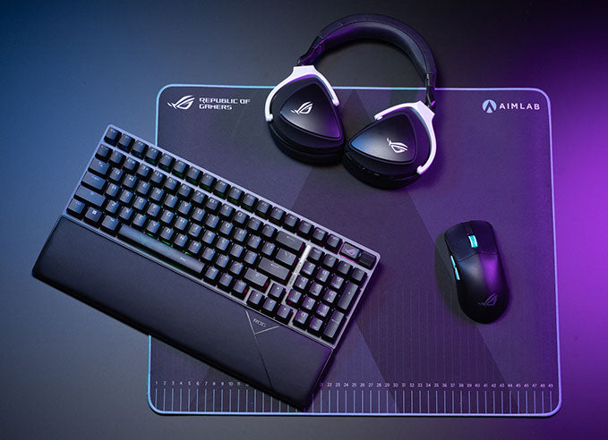 A set of ROG gaming peripherals on the desk with RGB lighting.
