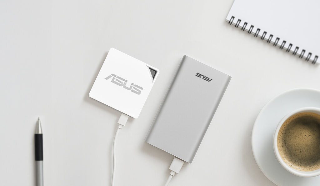 On the desk, there is coffee, a notebook and a pen, and an RT-AX50 Go powered by a portable charger.