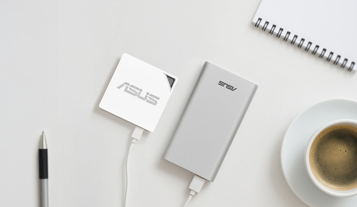 On the desk, there is coffee, a notebook and a pen, and an RT-AX50 Go powered by a portable charger.