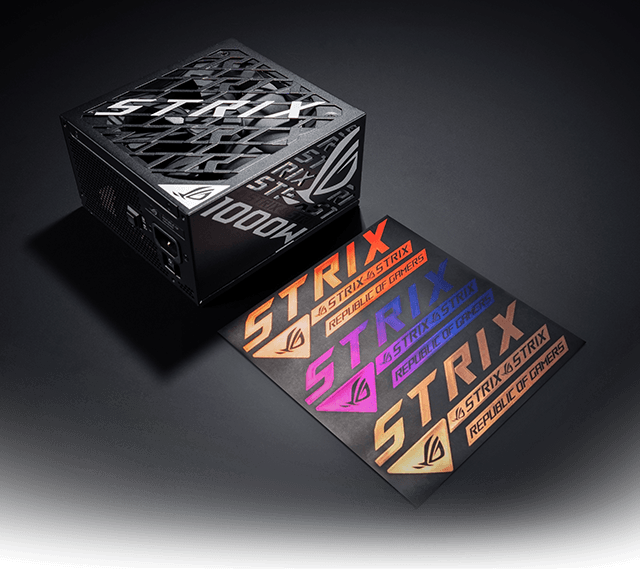 A black ROG Strix 1000W power supply shown at an angle on a dark background, with three colorful Strix logo stickers placed beside it.
