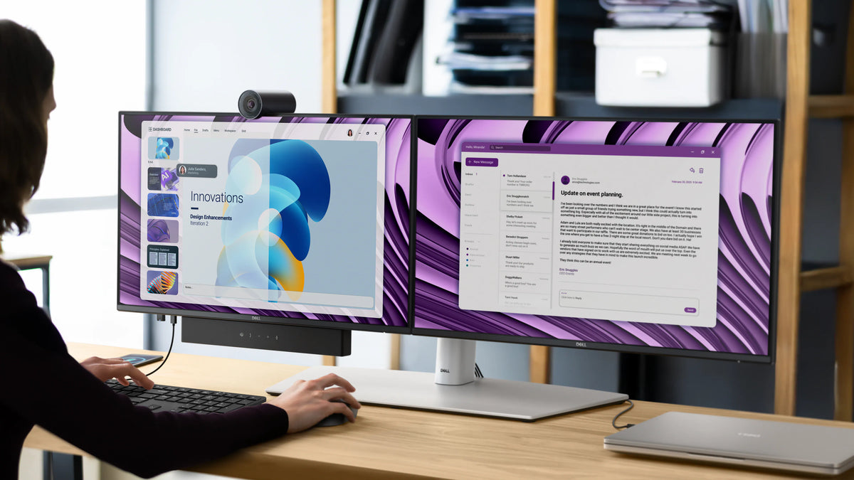 A person working on two Dell Pro P 24 USB-C Hub Monitors on a desk with a mouse, keyboard, and laptop.