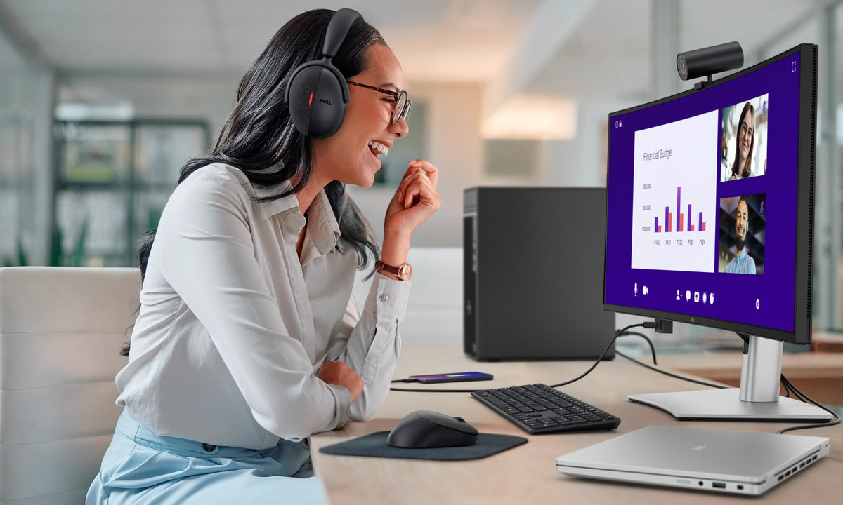 Woman working on a Dell Pro 34 Plus USB-C Hub Monitor while wearing a headset.
