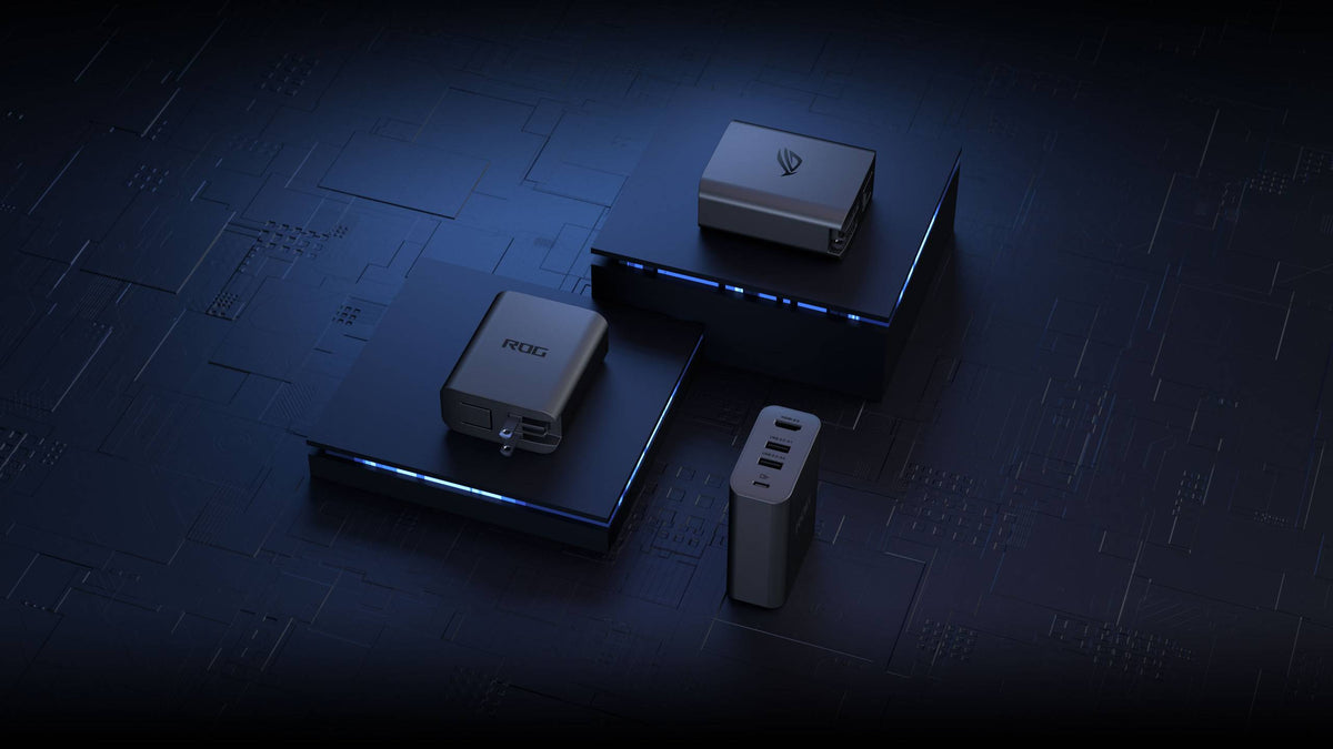 Three ROG 100W Gaming Charger Docks, arranged on a black printed metal surface, with two devices on elevated stands, and the final resting on its edge directly on the metal. Emphasis on all three sides of the device.