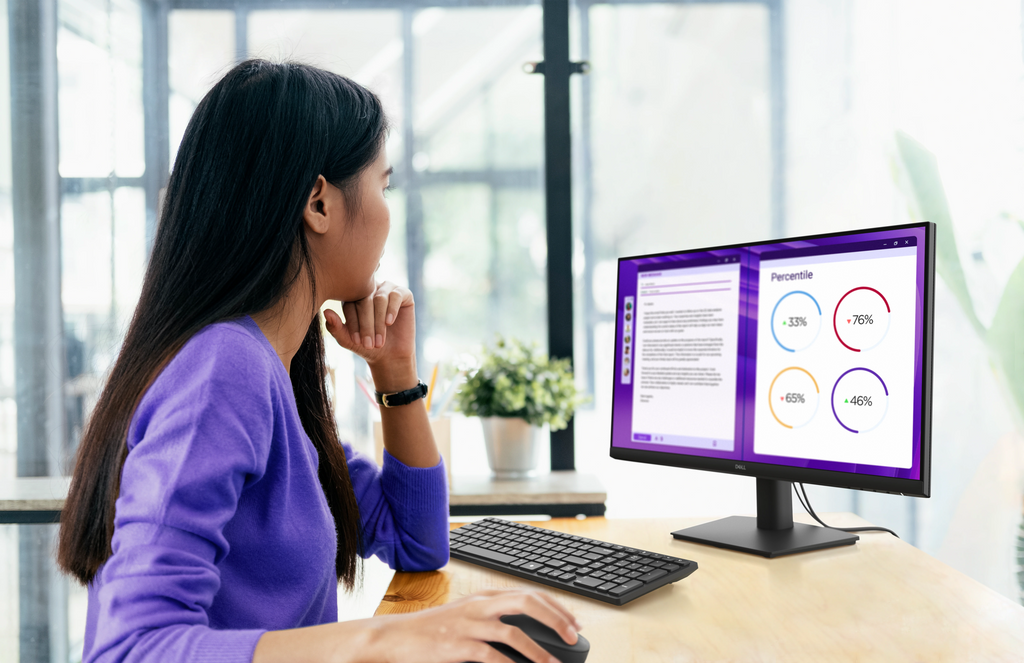 An office worker using a Dell Pro 24 Monitor connected to a Dell laptop.