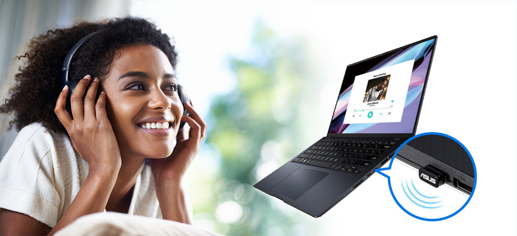 Woman wears wireless headphones and smiles while listening to music from a laptop connected via an ASUS USB-BT540 dongle.