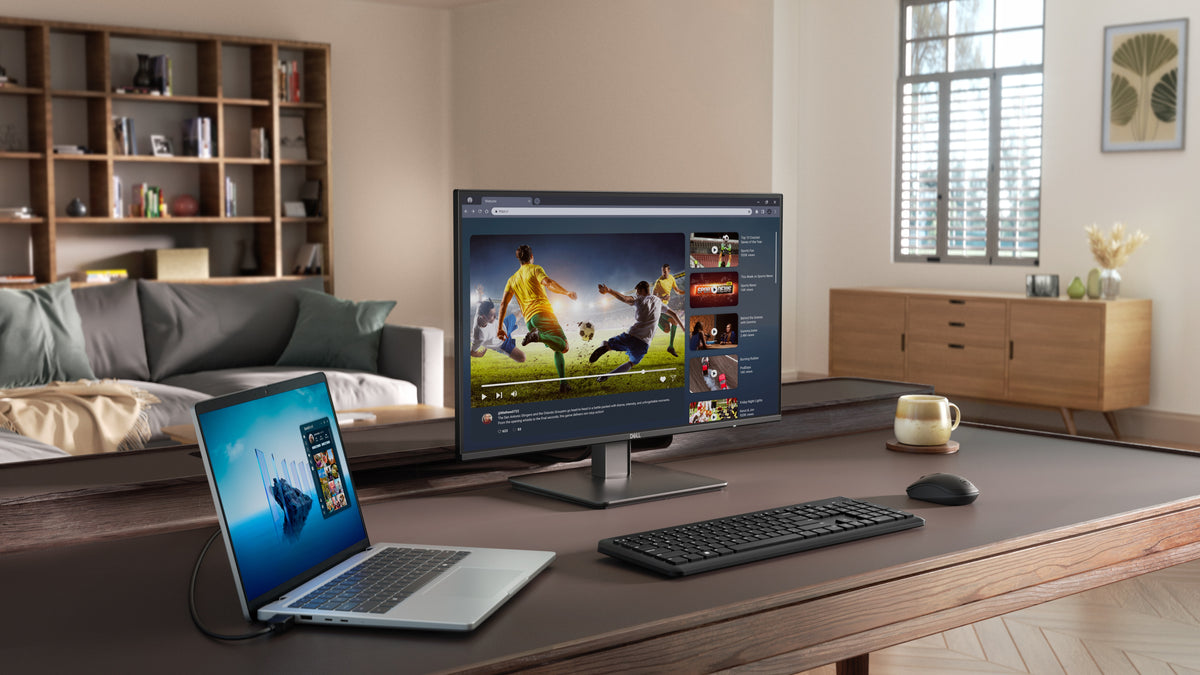 Image of the SE2726D monitor on a desk surrounding by a laptop and other Dell accessories and peripherals.